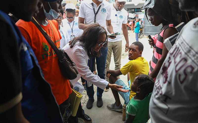 Doctor with children in a street in Haiti